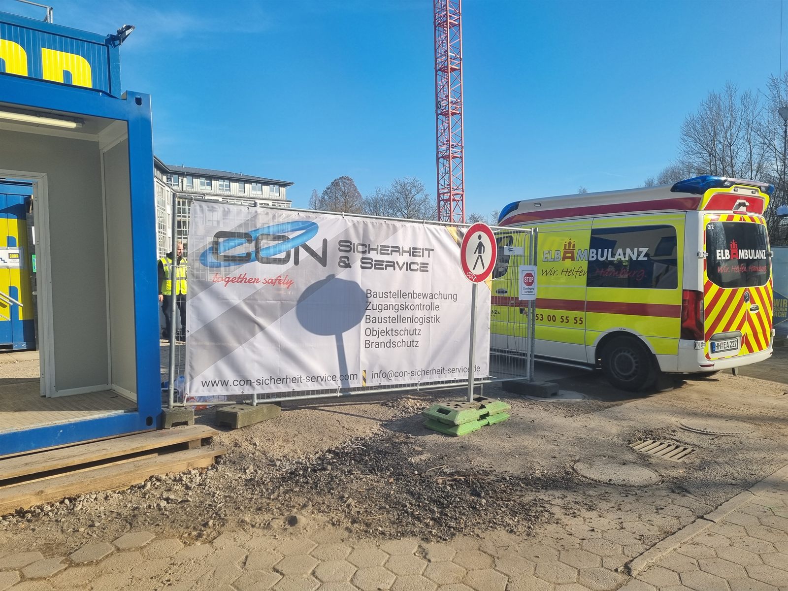 Baustelle mit CON Bauzaunbanner und Rettungswagen