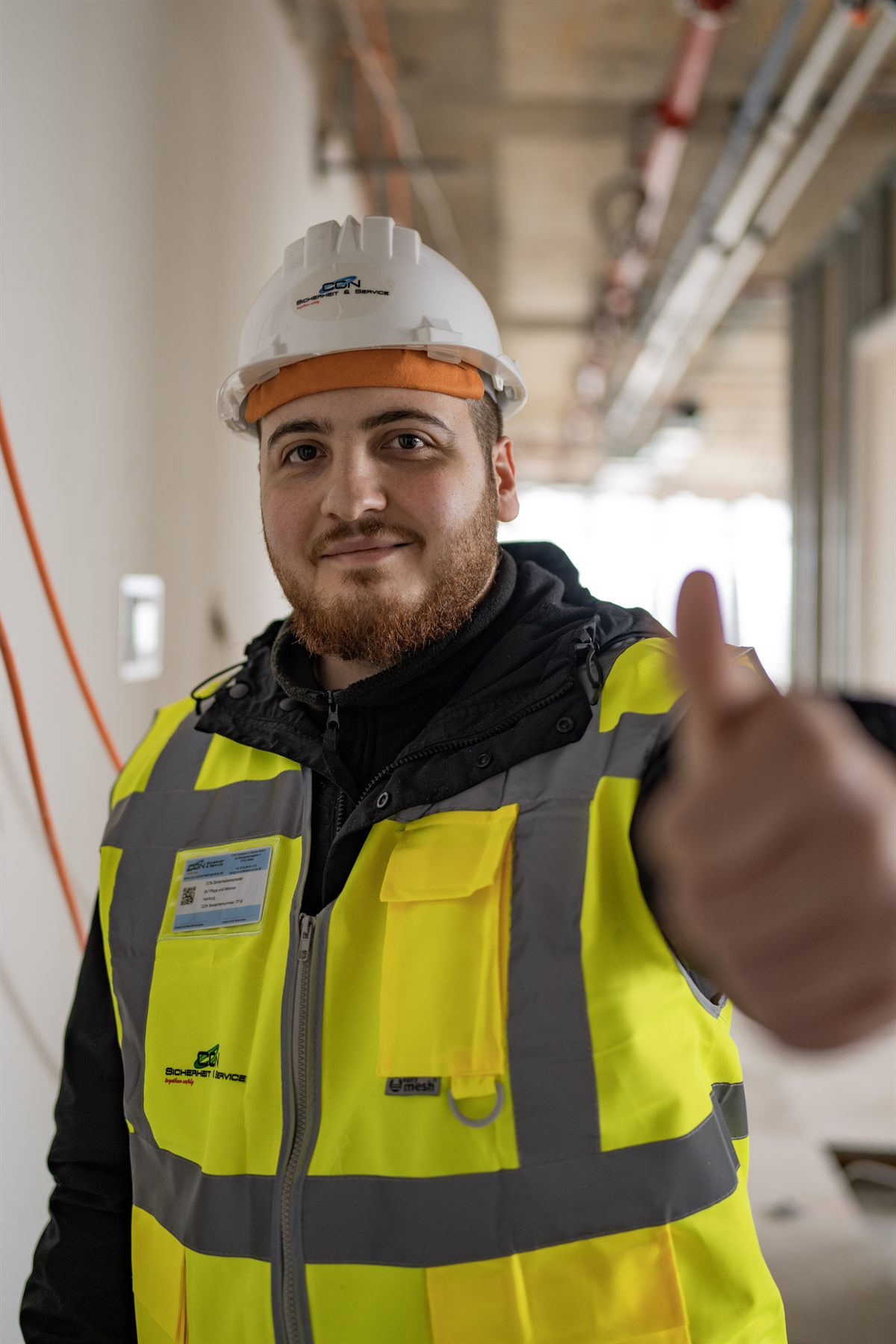 CON Mitarbeiter mit Helm und Warnweste auf einer Baustelle